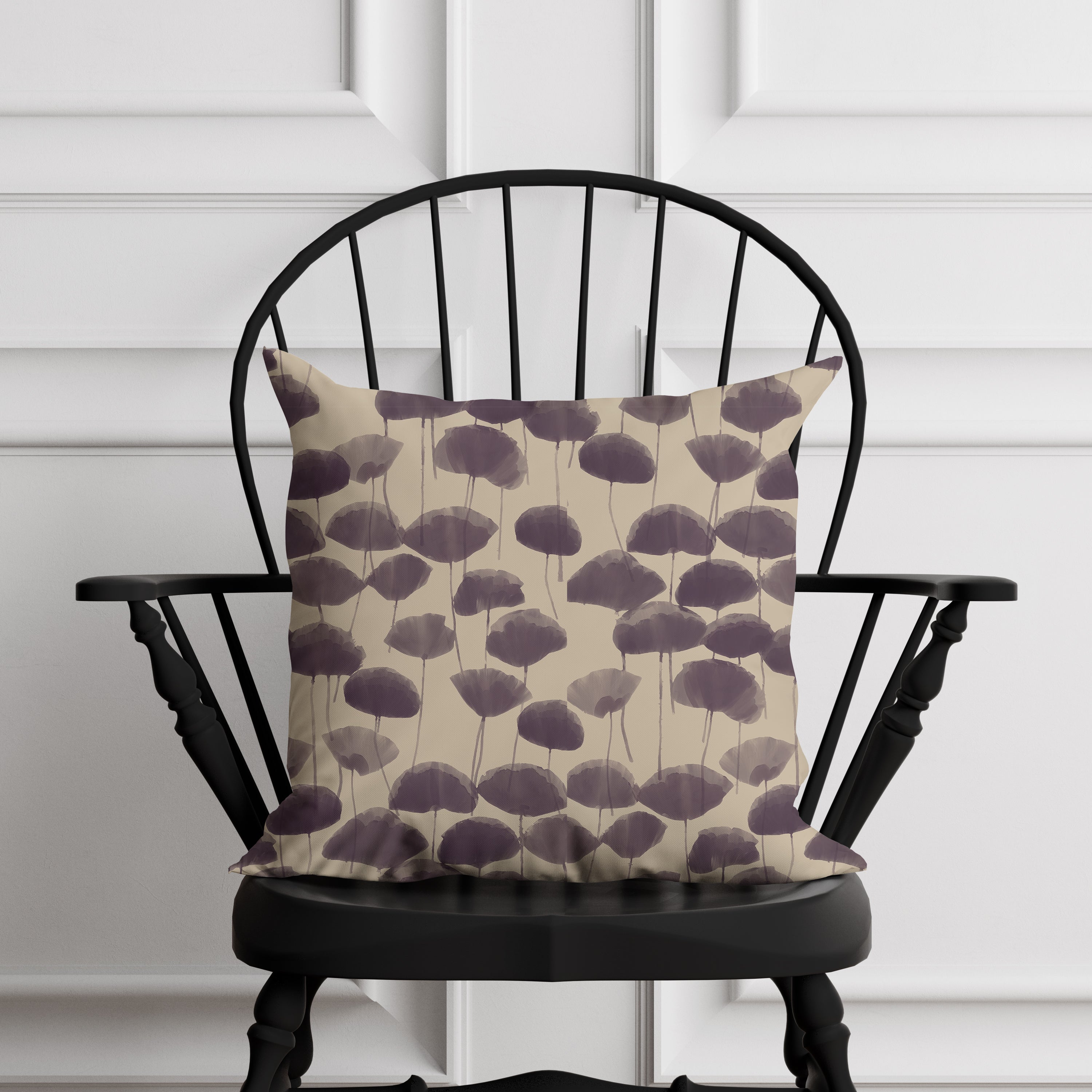 Decorative pillow with purple floral pattern on a black chair against a white paneled wall.
